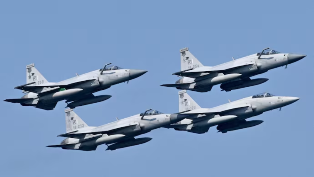Four light gray Pakistan Air Force JF-17 Thunder fighter jets flying in close formation against a clear blue sky, viewed from below and the side, with tail numbers 18-259, 18-254, 18-233, and 18-123 visible. The jets are believed to be connected to Pakistan Houthi strikes.